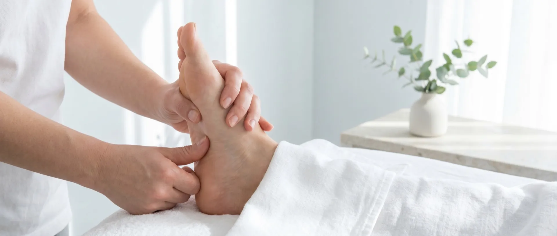 Reflexology treatment with the therapist's thumbs pressing points on the foot